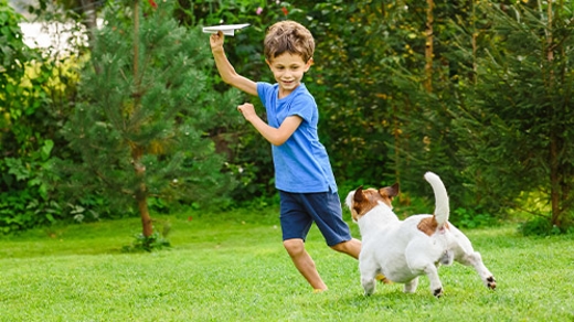 kid playing with dog outside